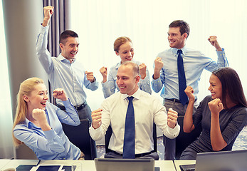 Image showing business people celebrating victory in office