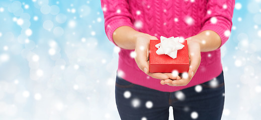 Image showing close up of woman in pink sweater holding gift box