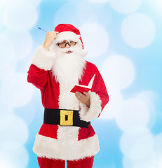 Image showing man in costume of santa claus with notepad