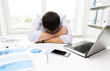 Image showing businessman with laptop and papers in office