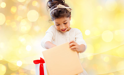 Image showing smiling little girl opening gift box