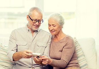 Image showing happy senior couple with camera at home