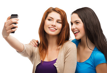 Image showing two smiling teenagers with smartphone