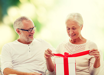 Image showing happy senior couple with gift box at home