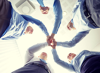 Image showing smiling group of businesspeople standing in circle