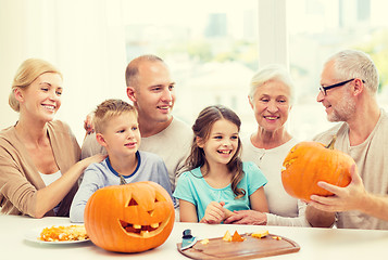 Image showing happy family sitting with pumpkins at home