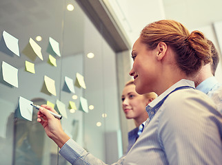 Image showing smiling business people with marker and stickers