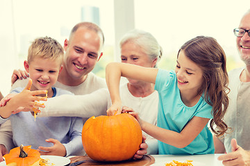 Image showing happy family sitting with pumpkins at home