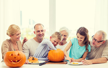 Image showing happy family sitting with pumpkins at home