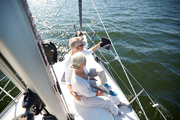 Image showing senior couple with tablet pc on sail boat or yacht