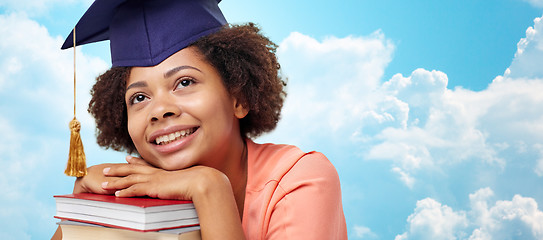 Image showing happy african bachelor girl with books over sky