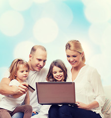 Image showing happy family with laptop computer and credit card