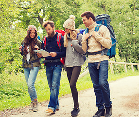 Image showing group of smiling friends with backpacks hiking