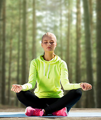 Image showing happy young woman doing yoga outdoors