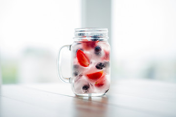 Image showing close up of fruit water in glass mug on table