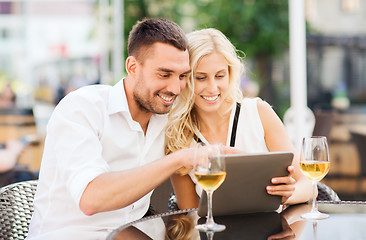 Image showing happy couple with tablet pc at restaurant lounge