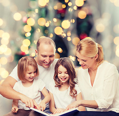 Image showing happy family with book at home