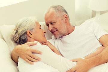 Image showing happy senior coupler lying in bad at home