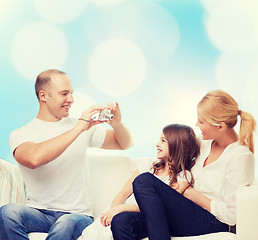 Image showing happy family with camera at home