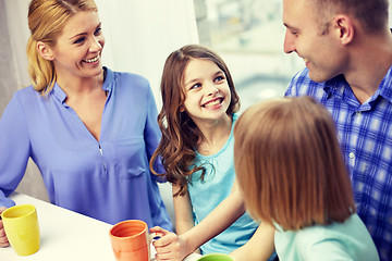Image showing happy family drinking tea with cups at home
