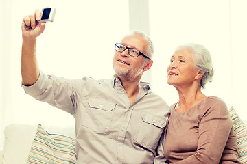 Image showing happy senior couple with camera at home