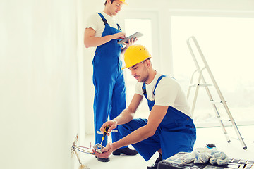 Image showing builders with tablet pc and equipment indoors