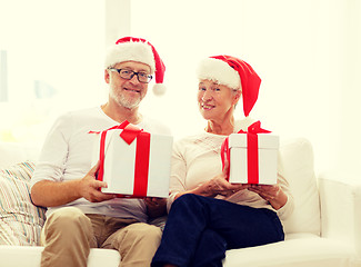 Image showing happy senior couple in santa hats with gift boxes