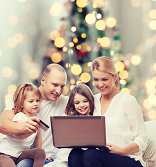 Image showing happy family with laptop computer and credit card