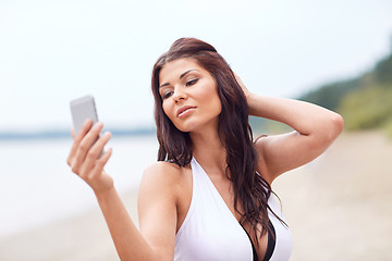 Image showing young woman taking selfie with smartphone