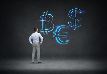 Image showing businessman looking at currency symbols