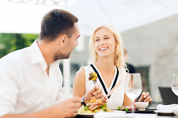 Image showing happy couple eating dinner at restaurant terrace