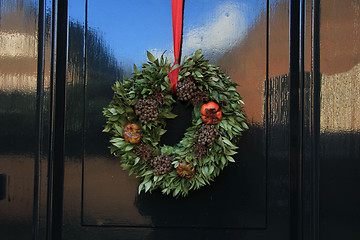 Image showing Classic christmas wreath with decorations on a door