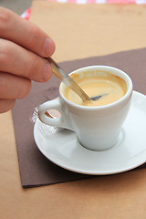 Image showing Man stiring an espresso