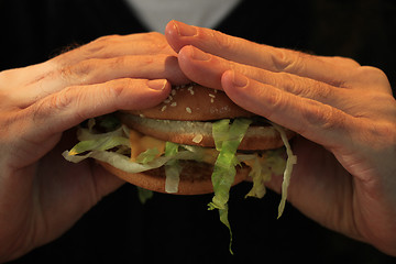 Image showing Man holding a hamburger