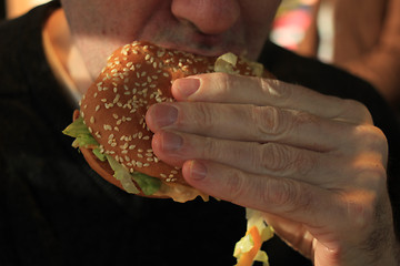 Image showing Man holding a hamburger