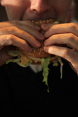 Image showing Man holding a hamburger