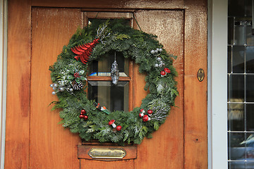 Image showing Classic christmas wreath with decorations on a door