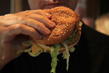 Image showing Man holding a hamburger