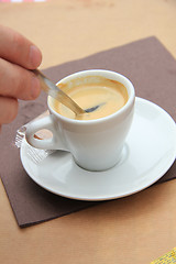 Image showing Man stiring an espresso