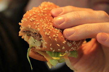 Image showing Man holding a hamburger