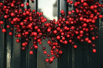 Image showing Berry christmas wreath with decorations on a door