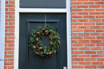 Image showing Classic christmas wreath with decorations on a door