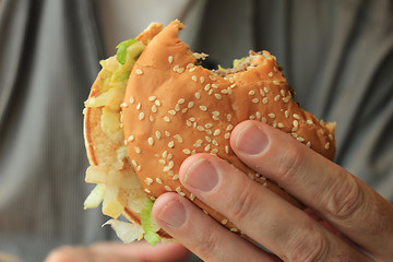 Image showing Man holding a hamburger