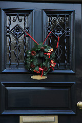 Image showing Classic christmas wreath with decorations on a door