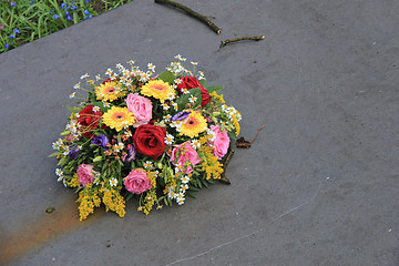 Image showing Sympathy flowers on a tombstone