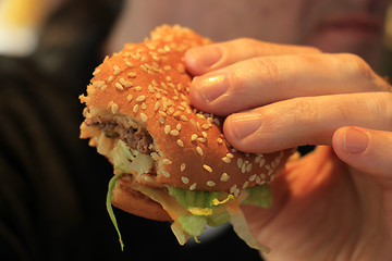 Image showing Man holding a hamburger