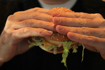 Image showing Man holding a hamburger