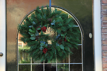 Image showing Classic christmas wreath with decorations on a door