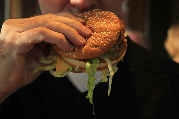 Image showing Man holding a hamburger