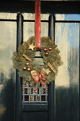 Image showing Classic christmas wreath with decorations on a door